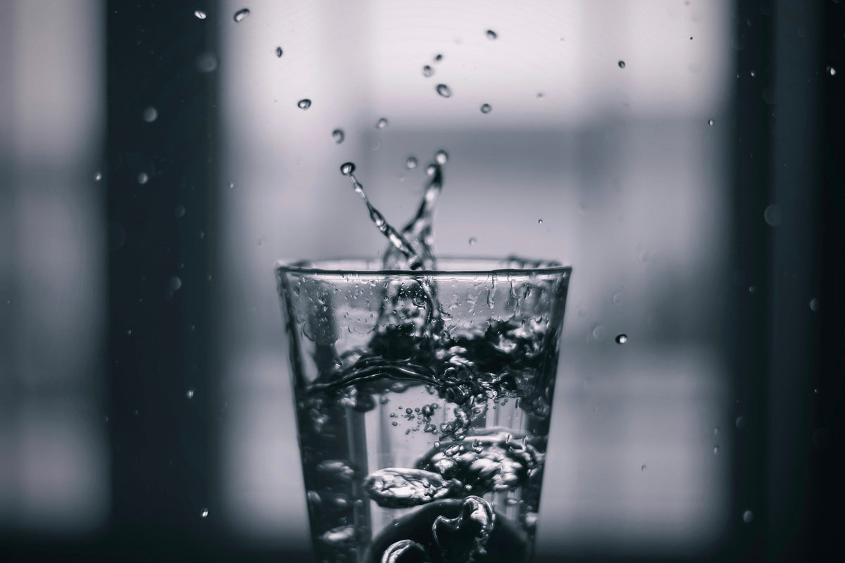 Clear water splashing into a modern drinking glass